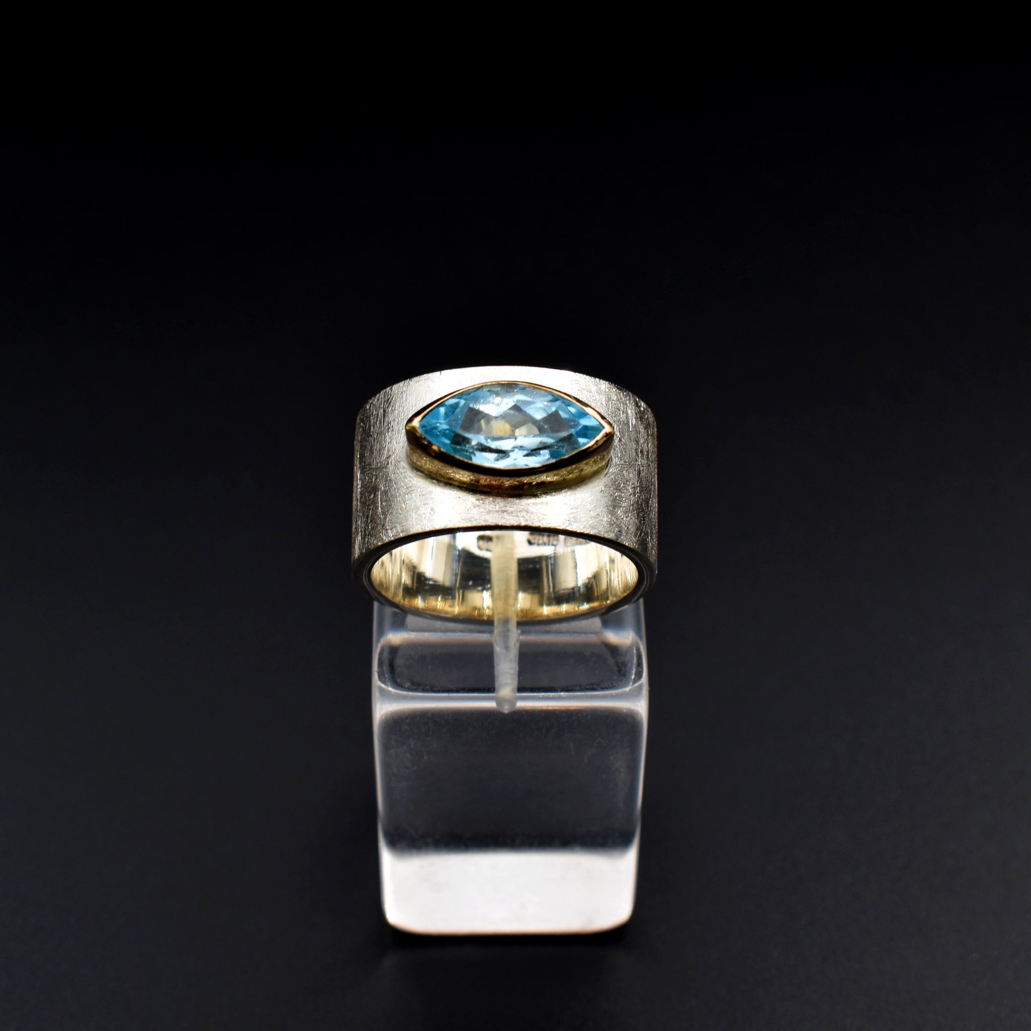 This document provides a crafted description for a handmade ring named 'Azure Elegance.' The ring features a subtly wide silver band with a matte finish and showcases a marquise-cut aquamarine at the top, embraced by a 14-karat yellow gold bezel. The description highlights the handcrafted nature, unique design, and key materials used, emphasizing its timeless beauty and modern allure. Additionally, the document includes suggested names and tags for the ring to enhance its discoverability on an eshop page.