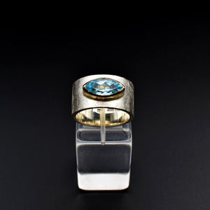 This document provides a crafted description for a handmade ring named 'Azure Elegance.' The ring features a subtly wide silver band with a matte finish and showcases a marquise-cut aquamarine at the top, embraced by a 14-karat yellow gold bezel. The description highlights the handcrafted nature, unique design, and key materials used, emphasizing its timeless beauty and modern allure. Additionally, the document includes suggested names and tags for the ring to enhance its discoverability on an eshop page.