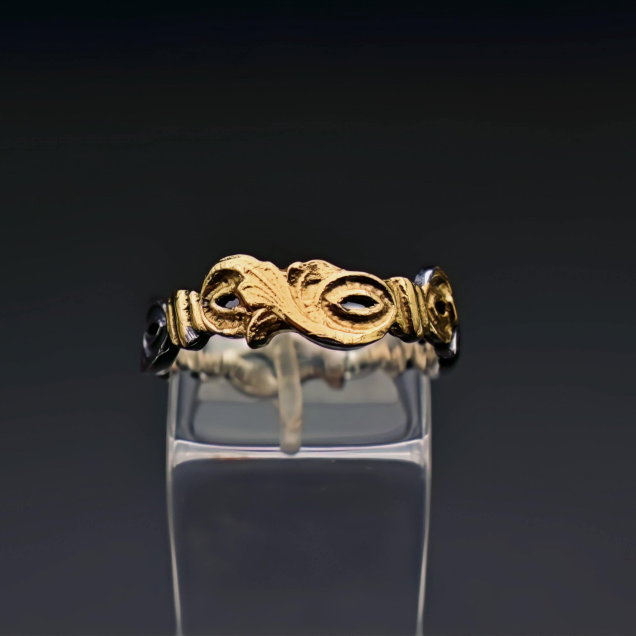 The text describes a handcrafted ring made of sterling silver and embellished with delicate engravings of leaves. The engravings are inspired by nature's beauty and the delicate veins of leaves. The ring also features a subtle glimmer of 22-karat gold infused using the traditional Keum-Boo technique.  This ring is a perfect example of the fusion of nature's artistry with the craftsmanship of human hands. It embodies elegance, individuality, and a timeless appreciation for the beauty of nature.