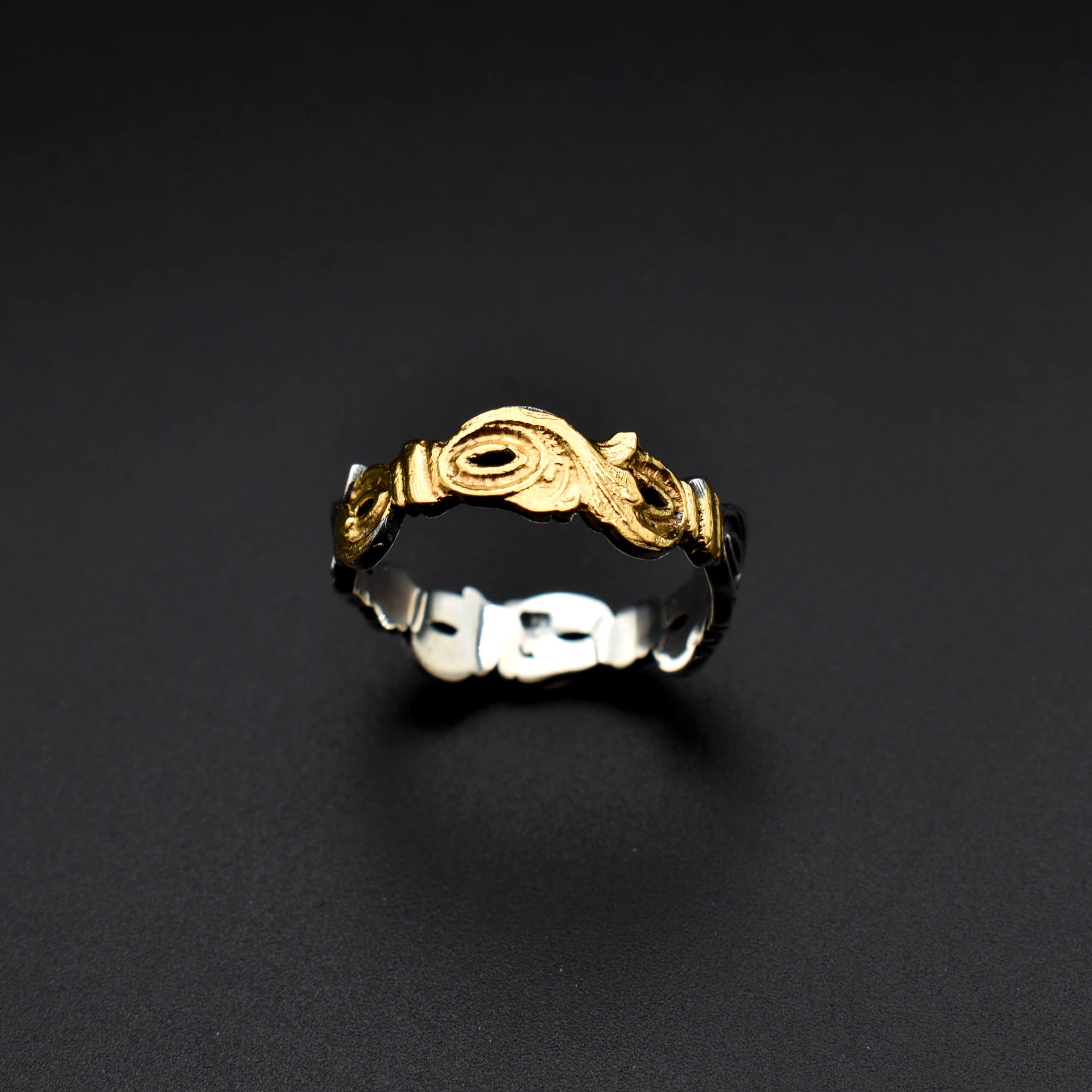 The text describes a handcrafted ring made of sterling silver and embellished with delicate engravings of leaves. The engravings are inspired by nature's beauty and the delicate veins of leaves. The ring also features a subtle glimmer of 22-karat gold infused using the traditional Keum-Boo technique.  This ring is a perfect example of the fusion of nature's artistry with the craftsmanship of human hands. It embodies elegance, individuality, and a timeless appreciation for the beauty of nature.