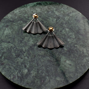 This file contains a concise description of handcrafted earrings made from sterling silver and 14K gold. The earrings have a unique hand fan shape inspired by straw basket textures, with a small gold granule at the top. They are described as elegant, versatile, and suitable for any occasion.