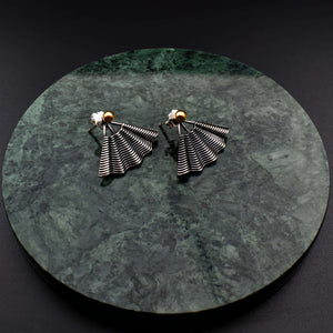 This file contains a concise description of handcrafted earrings made from sterling silver and 14K gold. The earrings have a unique hand fan shape inspired by straw basket textures, with a small gold granule at the top. They are described as elegant, versatile, and suitable for any occasion.