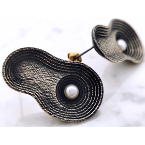 Handcrafted silver earrings inspired by a geographical formation in Peru called Moray crops. T he earrings are oxidized and have at the centre one natural white pearl in each of the earring.