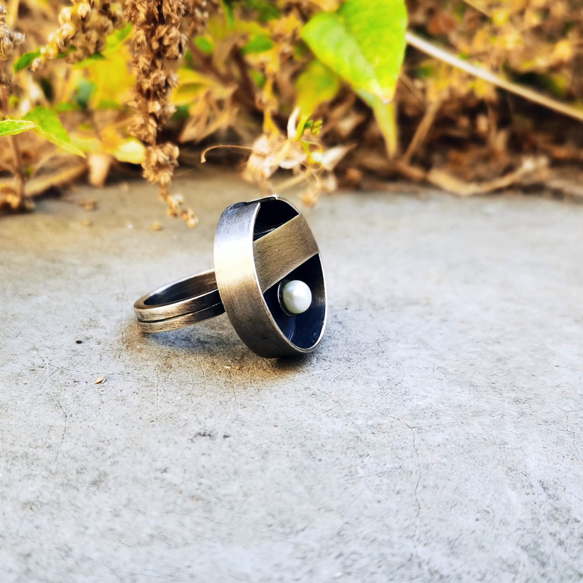 Minimal handcrafted silver ring with a natural white pearl at the centre of the ring, inspiration came from a zen garden in Japan. The ring is oxidized.